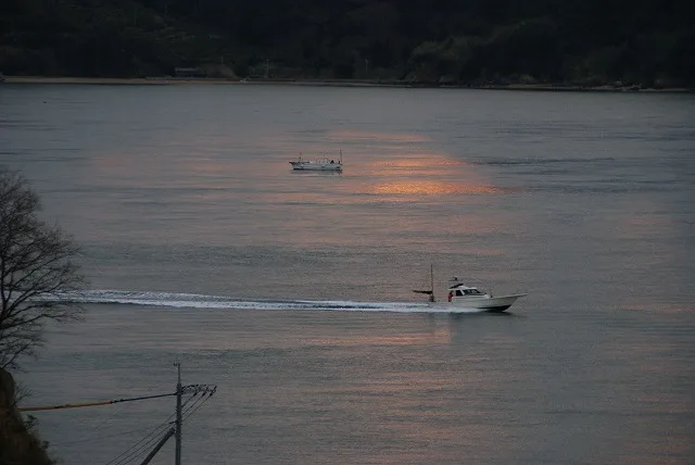恵みの丘から見る夕焼けが反射した海と船